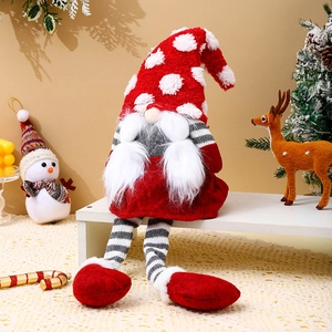 Detail of a Christmas gnome plush with red polka dot hat and striped long legs