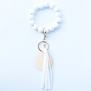 Porte-clés bracelet en perles blanches avec pompon en cuir et breloque en bois