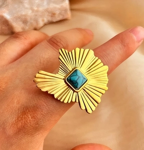 Detailed view of an irregular 18k gold-plated ring set with a square turquoise stone