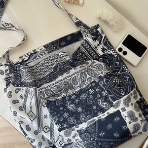 Detail view of large paisley bohemian cotton tote bag with casual lifestyle accessories