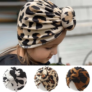 Detail view of infant knot beanies with leopard and cow prints in soft breathable fabric