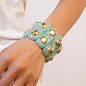 Detail view of mint green marble resin stretch bracelet with golden metal studs