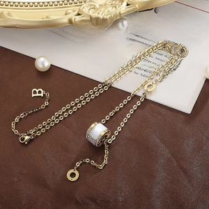 Macro detail of gold cylinder pendant with cat eye finish and crystal trim on chain