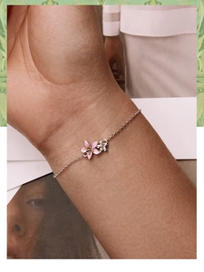 Close-up of elegant S925 silver bracelet featuring pink enamel flowers on a model's wrist