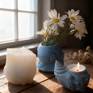 Detailed view of conch shell candle and seashell vase with daisy in soft natural light