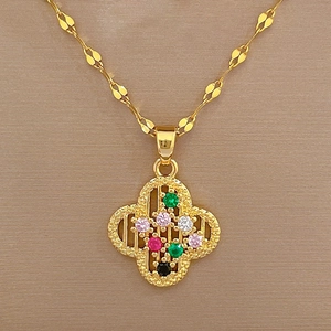 Macro detail of gold four-leaf clover pendant with colorful gemstones on a fine chain