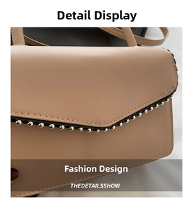 Detail view of beige PU leather handbag with black edge trim and silver metallic studs