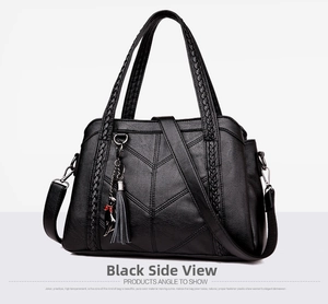 Detail view of black faux leather tote bag with V-quilted texture and cat charm