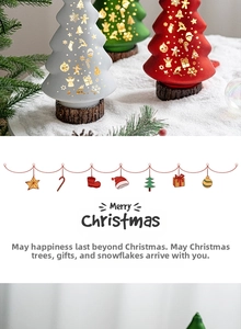 Detail of frosted Christmas tree figurines with golden snowflakes on wood bases