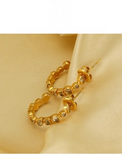 Detail of 18k gold-plated U-shaped earrings with inlaid geometric rhinestones and crystals
