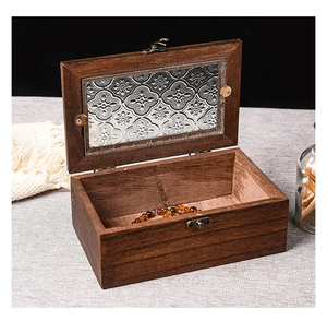 Detail of vintage wooden storage box with embossed flower glass lid and metal clasp