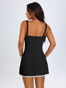 Elegante abito sottoveste nero con pizzo bianco sul fondo, vista posteriore della modella, chic