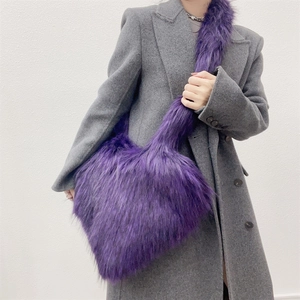 Detail of a large purple faux fur heart-shaped shell bag on a grey wool coat