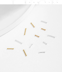 Dettaglio macro di borchie per orecchie in argento S999 con terminali a sfera oro e argento