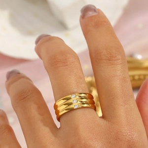 Detail of 18K gold plated triple band ring with three sparkling round cubic zirconia stones