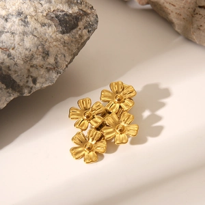 Détail d'une pince à cheveux en acier inoxydable doré mat avec quatre motifs floraux