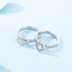 Macro shot of hexagonal and square rings with micro-pave cubic zirconia on light blue background