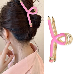 Macro shot of pencil-shaped hair claw clip in pink and gold with model wearing effect