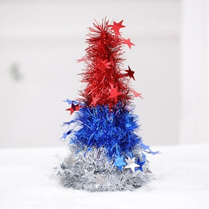 Close-up of three-tier red, blue, and silver tinsel tree with star sequins on faux snow