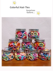 Nine clear jars filled with colorful high-elasticity hair ties on a wooden surface