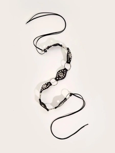 Detail of punk style black leather waist belt with silver metal studs and eyelet rings