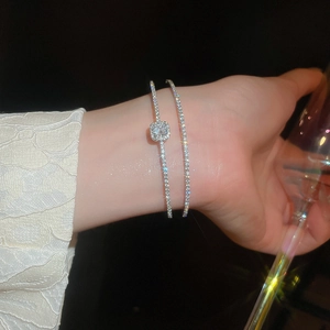 Detail of silver double-layered zircon bow bracelet showing sparkling square crystals on wrist