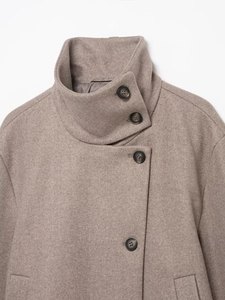 Detailed close-up of khaki wool coat featuring high collar and premium black buttons
