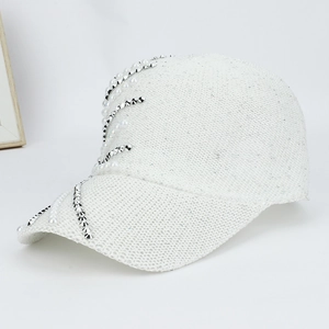 Detail of white baseball cap with elegant pearls and silver studs on the mesh fabric