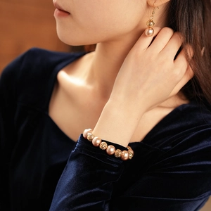 Detailed view of elegant pink pearl and hollow gold bead necklace and earring set