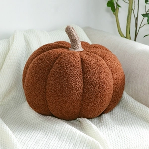 Textura detallada de un cojín suave con forma de calabaza en forro polar sherpa naranja