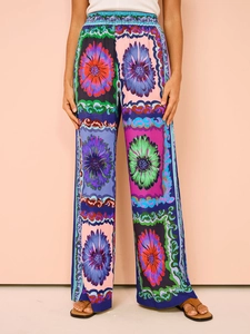 Close-up of women's wide leg trousers featuring vibrant geometric floral patterns