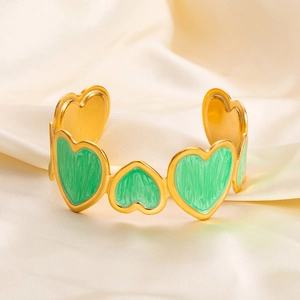 Detail of a 18K gold plated heart bracelet with green enamel on a silk background