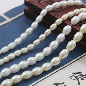 Perle ovali bianco crema per creazione gioielli fai-da-te su un libro stile vintage