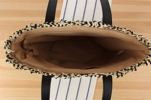 Internal view of the woven bag showing the brown lining, zipper pocket, and paper label