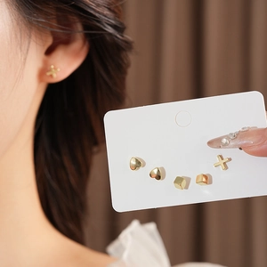 Detailed set of gold geometric stud earrings featuring heart, square, and cross shapes