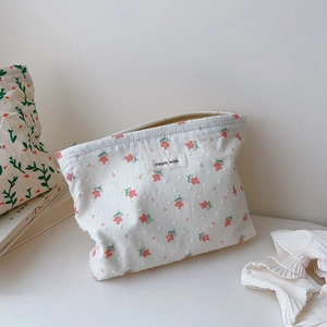 Detail of floral cotton makeup bag featuring a 'simple wish' woven label and zipper
