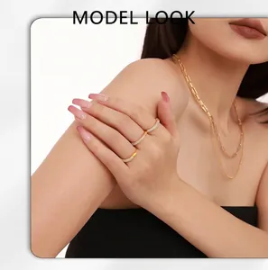 Model wearing gold ferris wheel rings with micro-paved zircons and layered necklaces
