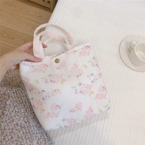 Gros plan d'un sac repas en coton matelassé à fleurs avec fermoir magnétique doré