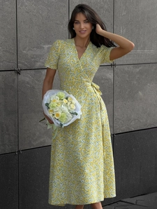 Detail of yellow floral wrap dress with V-neck, waist tie and flowing midi length