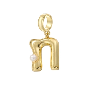 Vue détaillée du pendentif lettre n en métal doré orné d'une petite perle blanche