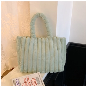 Detail of plush light green tote bag showing soft striped faux fur texture and handle