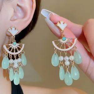Elegant ginkgo leaf tassel earrings with green crystal drops and pearls in gold finish
