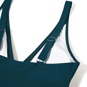 Detail of adjustable shoulder straps and textured fabric on dark green swimsuit