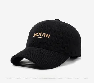 Detailed macro view of black waffle knit baseball cap with gold MOUTH embroidery