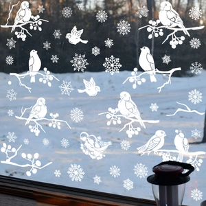White Christmas window decals featuring snow birds and snowflakes on a glass pane