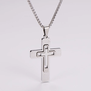 Detailed close-up of a silver hollow double-layer cross pendant on a stainless steel chain