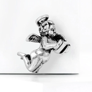 Detailed macro view of a silver angel brooch reading a book with metallic finish