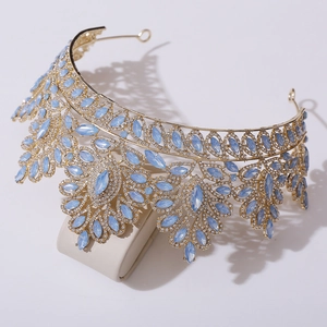 Detailed shot of golden baroque bridal crown featuring blue teardrop gems and rhinestones