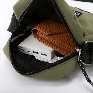 Olive green nylon crossbody bag showing main compartment with wallet and power bank