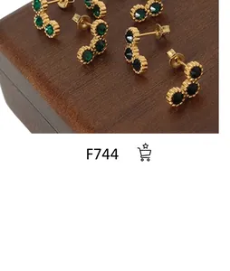 Détail d'un ensemble de boucles d'oreilles plaquées or 18K avec cristaux vert et noir